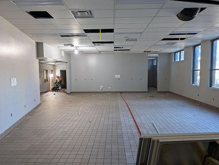 a large open room in progress with a tiled floor being layed